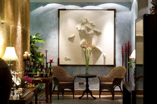 a table with chairs and a picture of a woman at Hotel Azahar in Murcia