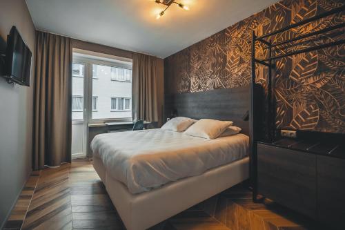 a bedroom with a large bed and a wall at Prado Next Door in Ostend