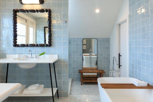 a bathroom with blue tiles and a sink and a tub at Winslow's Bungalows - Key West Historic Inns in Key West