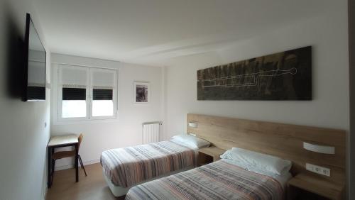 a hotel room with two beds and a window at Balentziaga in Azcoitia