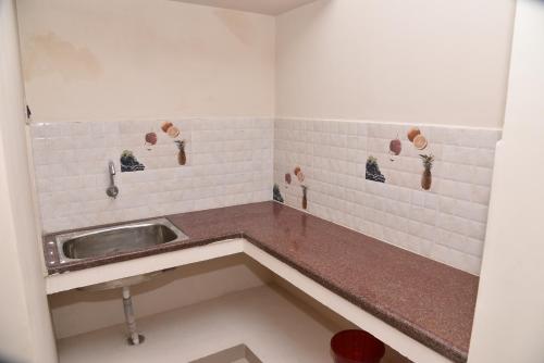 a kitchen with a sink in a room at Thirumalai Home Stay - Group & Family Stay Room VL Swami Malai Temple in Kumbakonam
