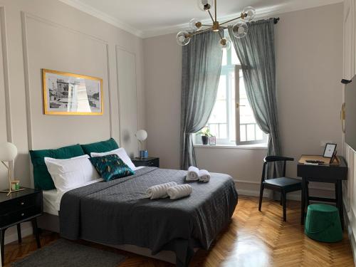 Schlafzimmer mit einem Bett, einem Schreibtisch und einem Fenster in der Unterkunft Dragonfly Residence in Belgrad