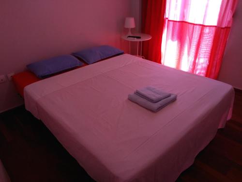 a bedroom with a white bed with two towels on it at Wonderful Apartment in central Athens in Athens