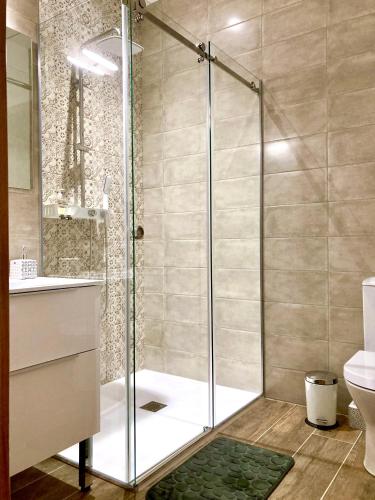 a shower with a glass door in a bathroom at Les Petits Cousins Du Québec - Chambres D’hôtes à Domme in Domme