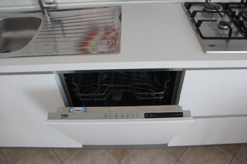 an open dishwasher in a white kitchen drawer at F&G 71100 - - Colazione inclusa - Box auto privato su richiesta in Foggia