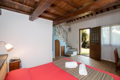 a bedroom with a red bed and a staircase at Residenza d'Epoca Pietra Di Ponente in Ciampino