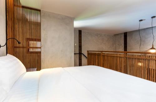 a bedroom with a large white bed in it at Ruang Tekuni in Legian