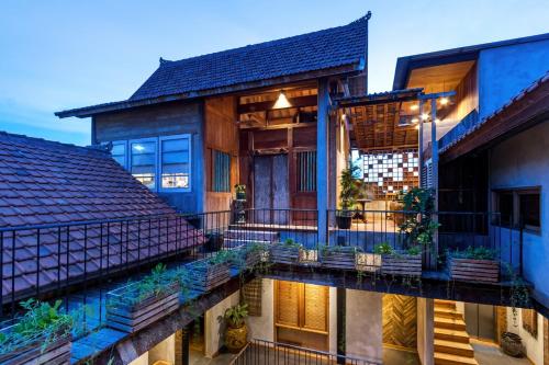 a house with a balcony with plants on it at Ruang Tekuni in Legian