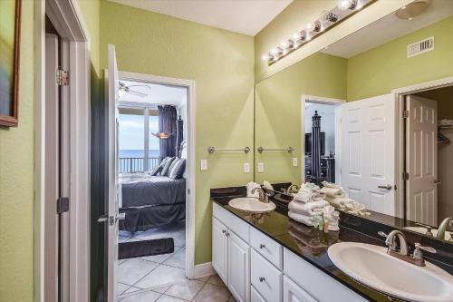 a bathroom with two sinks and a bedroom at San Carlos Unit 902 in Gulf Shores