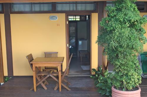 una mesa y sillas en el porche de una casa en Residencial Villafranca, en Boicucanga