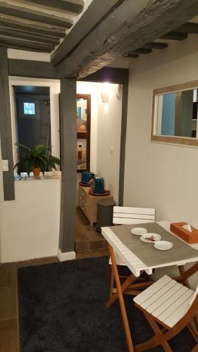 ein Esszimmer mit einem Tisch und Stühlen in einem Zimmer in der Unterkunft Bienvenue chez Greg in Honfleur