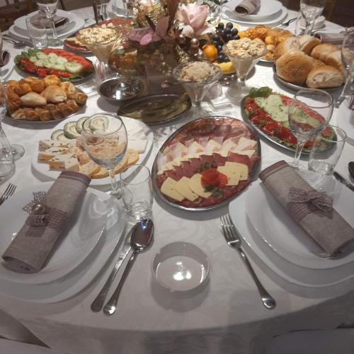 a table with many plates of food on it at Garni hotel Mali predah - novi deo in Knjazevac.