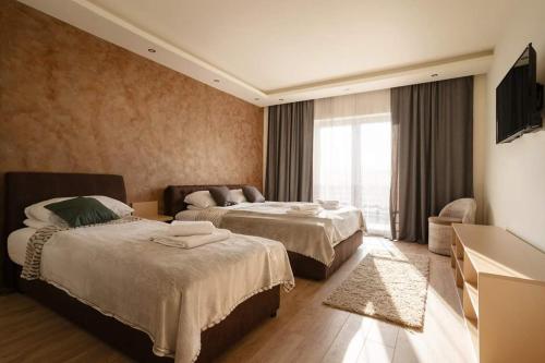 a hotel room with two beds and a television at Garni hotel Mali predah - novi deo in Knjazevac.