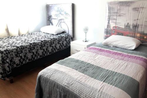 a bedroom with two beds and a mirror at La casa de Glo in Guadalajara