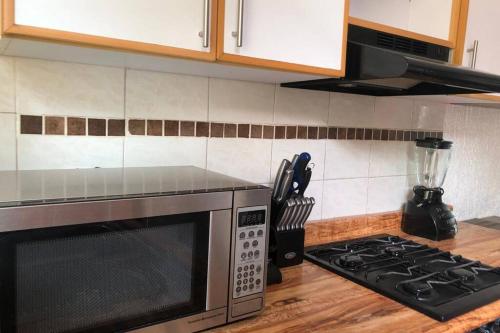 a kitchen counter with a microwave and a stove at La casa de Glo in Guadalajara
