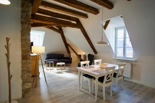 ein Wohnzimmer mit einem Tisch, Stühlen und einem Sofa in der Unterkunft Bärengasse Apartments in Freinsheim