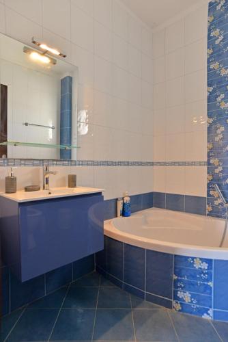 a bathroom with a tub and a sink and a mirror at VILLA KONSTANTINOS 6 bedrooms in Egina