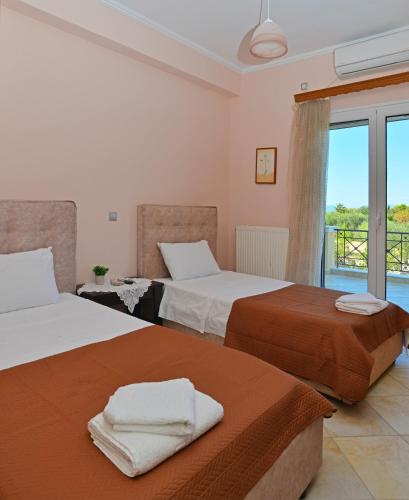 a bedroom with two beds and a balcony at VILLA KONSTANTINOS 6 bedrooms in Egina