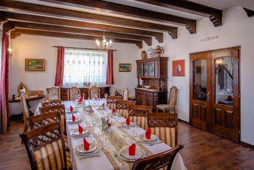 a dining room with a long table with red napkins on it at Pensiunea Curtea lui Toader in Simioneşti