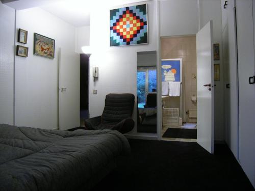 a bedroom with a bed and a chair and a mirror at B&B Middelheim in Antwerp