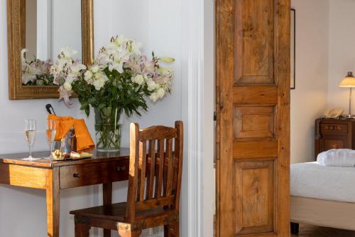 a table with a vase of flowers on a table with a chair at Residenza d'Epoca Pietra Di Ponente in Ciampino