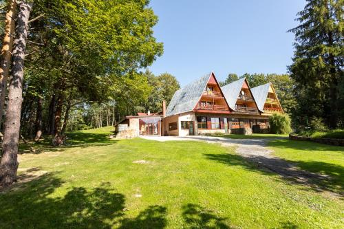ein großes Haus mit einem Gamer-Dach auf einem grünen Hof in der Unterkunft Horsky dom in Levoča