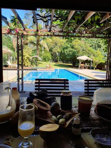 a table with food and drinks and a swimming pool at Fazenda Santa Clementina in Araras