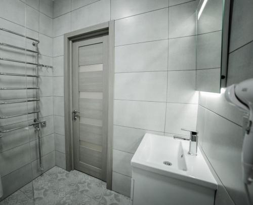 ein weißes Bad mit einem Waschbecken und einer Dusche in der Unterkunft Veronika in Poljana