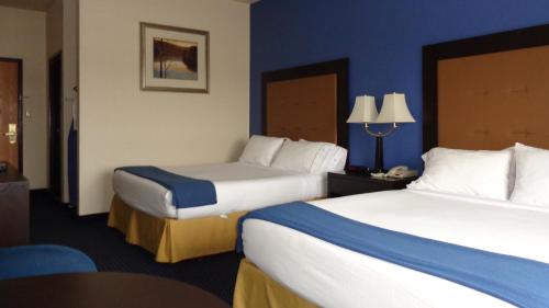 2 letti in una camera d'albergo con pareti blu di Holiday Inn Express & Suites New Buffalo, MI, an IHG Hotel a New Buffalo