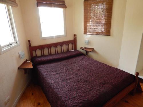 a bedroom with a bed in a room with two windows at Las Terrazas Resort & Apart-Cabañas in La Falda