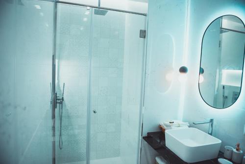 bagno con doccia, lavandino e specchio di TAM Serviced Apartments City Center No2 a Tirana