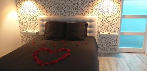 Un dormitorio con una cama con un corazón. en Gîte de la Daudière La Grange en Le Boupère