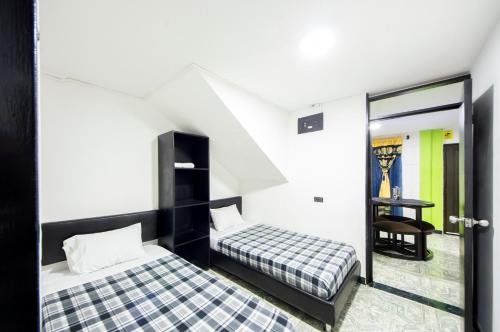 sypialnia z 2 łóżkami i stołem w pokoju w obiekcie Casa Quindio w mieście Armenia
