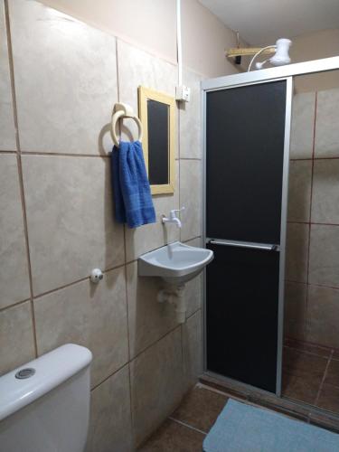 a bathroom with a toilet and a sink and a shower at Casa Aeroporto Pousada in Recife