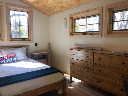 1 dormitorio con 1 cama, vestidor y ventanas en River Rock Retreat, en Idyllwild