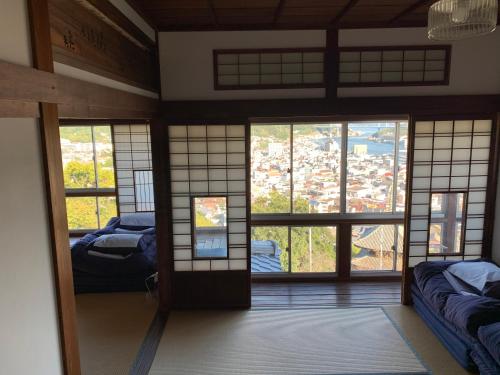 Onomichi Guest House Miharashi-tei في أونوميتشي: غرفة بأبواب ونوافذ في مبنى