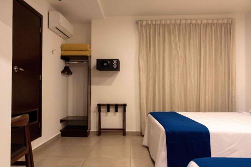 a hotel room with a bed and a window at Hotel Real Alma in Oaxaca City
