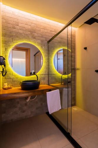 a bathroom with a sink and two mirrors at Pousada Kiriri in Itarema
