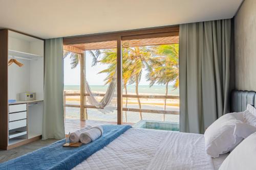 a bedroom with a bed with a view of the ocean at Pousada Kiriri in Itarema