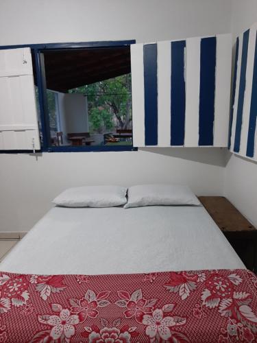 a bedroom with a bed with a red and white blanket at Estância Morro Do Frota in Pirenópolis