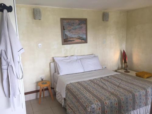 Suite Independente Por do Sol Ferradura في بوزيوس: غرفة نوم بسرير ودهان على الحائط