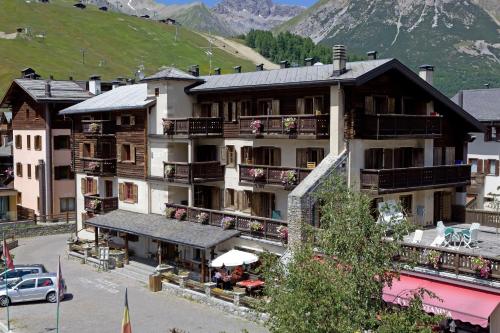 duży budynek z balkonami i stołami przed nim w obiekcie Hotel La Montanina w Livigno