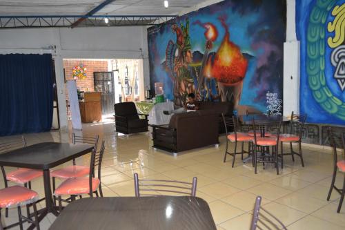 サン・フアン・テオティワカンにあるホテル ケツァールカリのダイニングルーム(テーブル、椅子、壁画付)