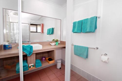 a bathroom with a sink and a mirror at Sea Spray Motel - Merimbula in Merimbula