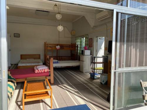 うるま市にあるエムスリーの二段ベッド2台とリビングルームが備わる客室です。