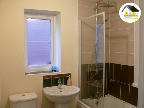 a bathroom with a toilet sink and a shower at B and R Serviced Accommodation, 3 Bedroom House with Free Parking, Super fast Wi-Fi 145Mbps and 4K smart TV, Barnard House in Amesbury