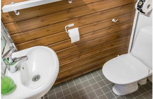 La salle de bains est pourvue de toilettes blanches et d'un lavabo. dans l'établissement Enjoy Ylläs - Cozy top floor apartment, à Ylläsjärvi