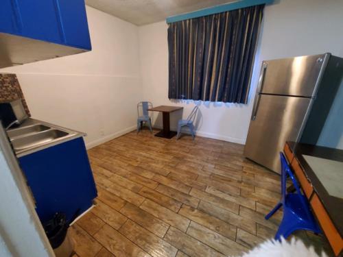 a kitchen with a stainless steel refrigerator and a table at Desert Hills Motel in Las Vegas