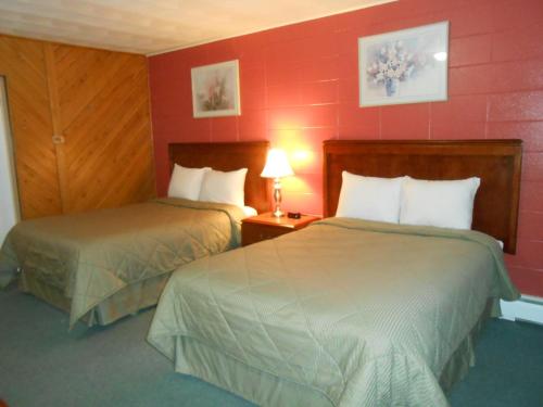 two beds in a hotel room with red walls at Aquarius Motel in Perth