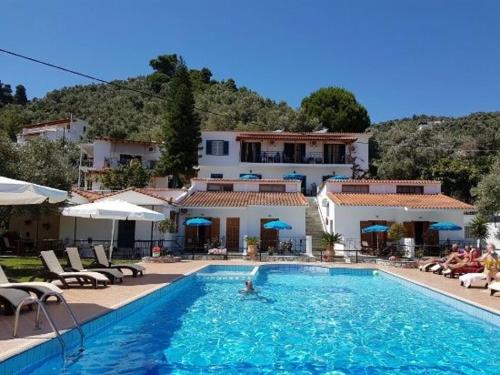 a person swimming in a swimming pool in front of a hotel at Villa Anni in Skiathos Town